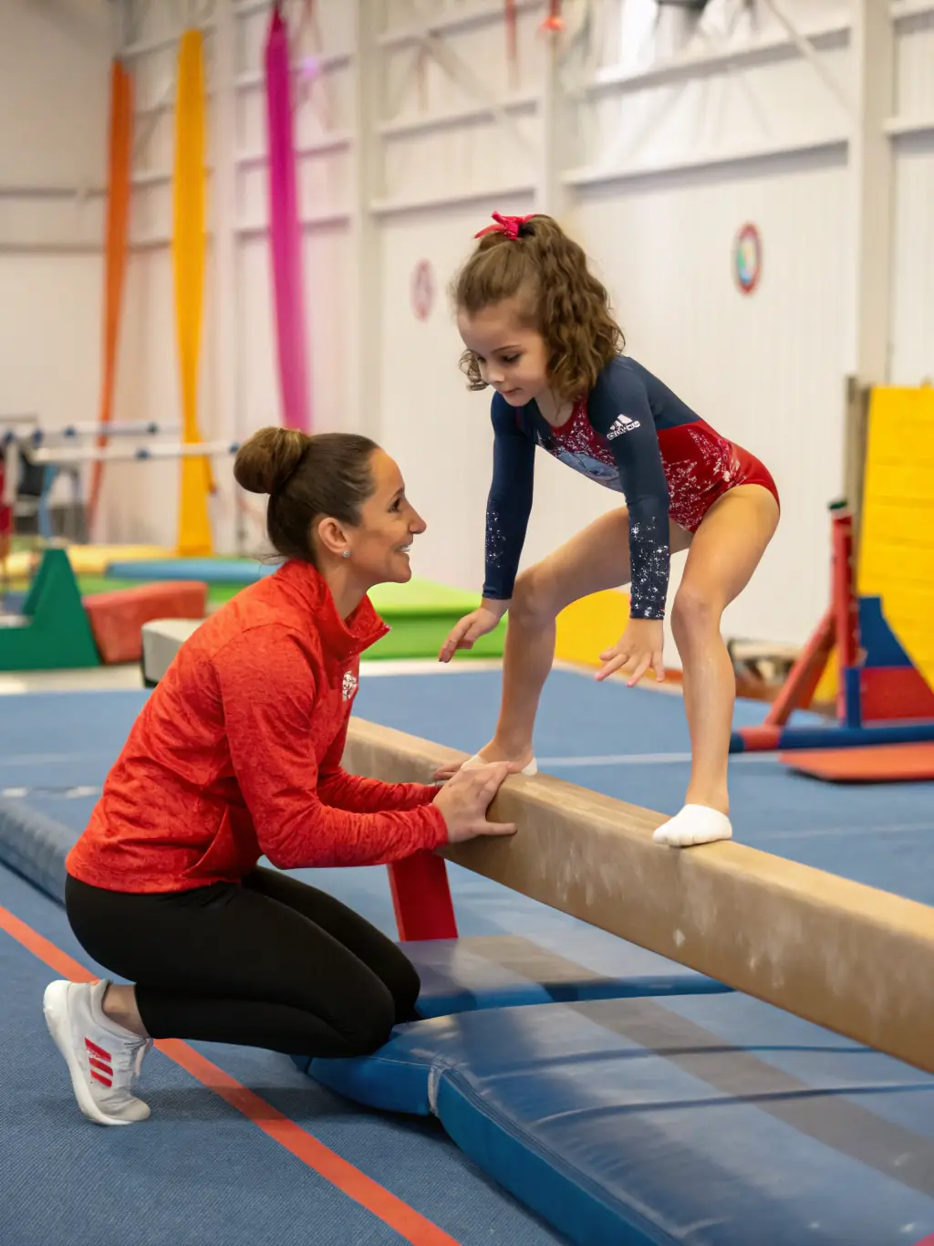 A coach providing personalized instruction to a twirler, focusing on specific techniques and performance aspects, illustrating the personalized coaching available at ARPAJON TWIRLING CLUB.